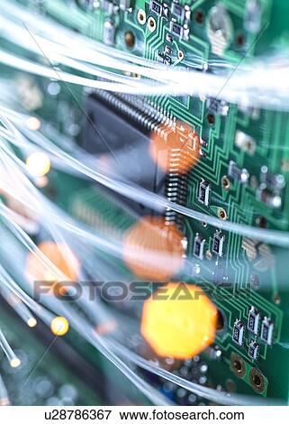 Stock Photo - Digital communication, conceptual image. Fibre optics carrying data over electronic circuitry on a laptop computer.. Fotosearch