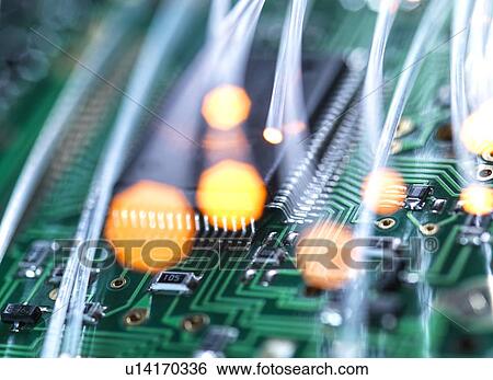 Stock Photograph - Digital communication, conceptual image. Fibre optics carrying data over electronic circuitry on a laptop computer.. Fotosearch