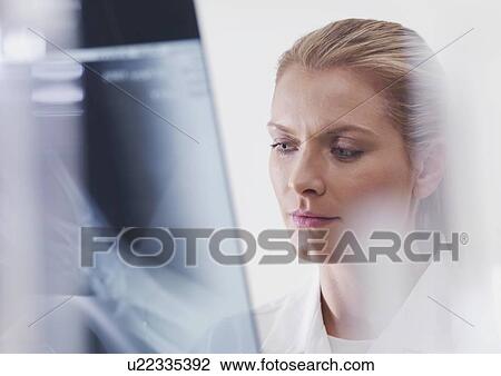 Stock Image - Doctor examining an X-ray.. Fotosearch