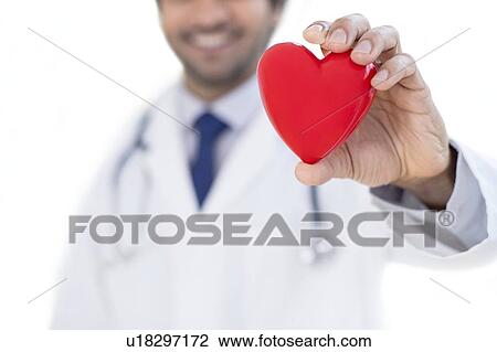 Stock Image - Doctor holding heart shape.. Fotosearch