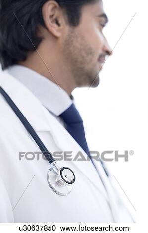 Stock Image - Doctor with stethoscope, looking away.. Fotosearch