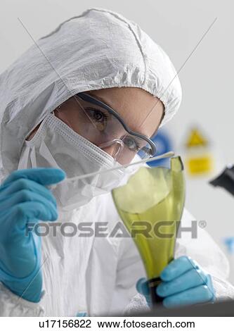 Stock Image - Forensic scientist collecting evidence by taking a DNA (deoxyribonucleic acid) swab from scene of crime bottle.. Fotosearch