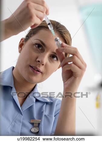 Picture - Healthcare worker preparing an injection.. Fotosearch