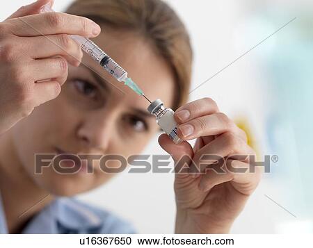 Stock Image - Healthcare worker preparing an injection.. Fotosearch