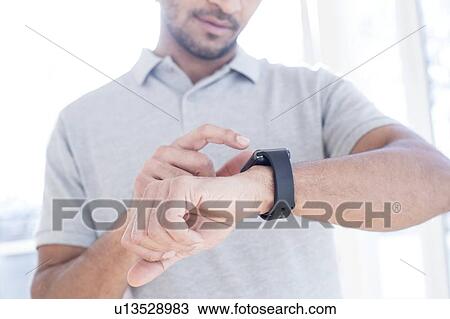 Man checking his smart watch. View Large Photo Image Stock Image - Man checking his smart watch.. Fotosearch