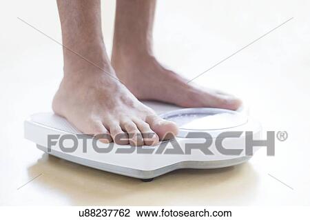 Man standing on weighing scales. View Large Photo Image Stock Image - Man standing on weighing scales.. Fotosearch