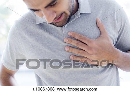 Stock Photo - Man touching his chest in pain.. Fotosearch