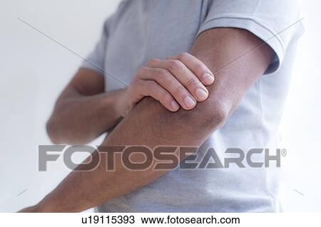 Man touching his elbow in pain. View Large Photo Image Stock Image - Man touching his elbow in pain.. Fotosearch