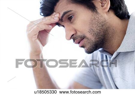 Stock Image - Man touching his forehead.. Fotosearch