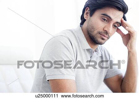 Stock Image - Man touching his forehead.. Fotosearch