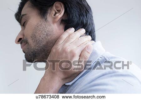 Stock Photo - Man touching his neck in pain.. Fotosearch