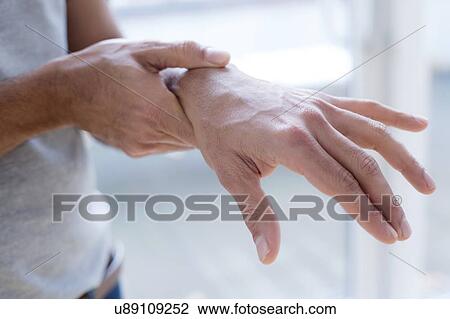 Man touching his wrist in pain. View Large Photo Image Stock Image - Man touching his wrist in pain.. Fotosearch
