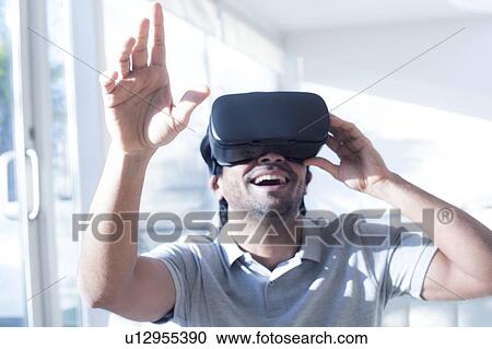 Stock Image - Man wearing virtual reality (VR) headset.. Fotosearch