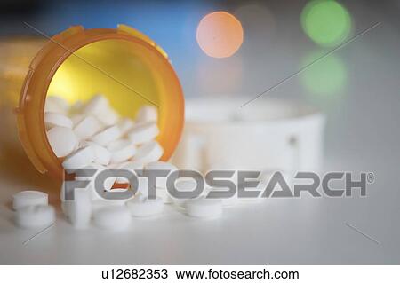 Stock Image - Pills spilling from bottle.. Fotosearch