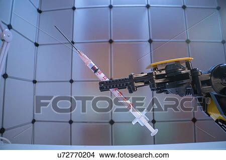 Robot arm holding syringe. View Large Photo Image Picture - Robot arm holding syringe.. Fotosearch