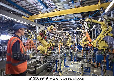 Apprentice engineer programming robots in car factory View Large Photo Image Stock Photo - Apprentice engineer programming robots in car factory. Fotosearch