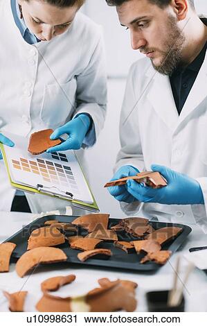 Archaeologist comparing pottery colours View Large Photo Image Stock Image - Archaeologist comparing pottery colours. Fotosearch