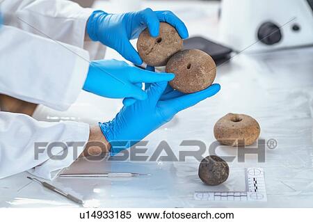 Archaeologists analyzing ancient weight in laboratory View Large Photo Image Stock Photography - Archaeologists analyzing ancient weight in laboratory. Fotosearch