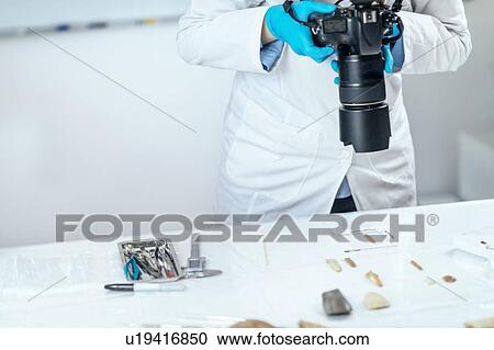 Stock Image - Archaeology researchers documenting artefacts. Fotosearch