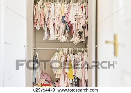 Assortment of baby clothing hung inside cupboard View Large Photo Image Stock Photo - Assortment of baby clothing hung inside cupboard. Fotosearch