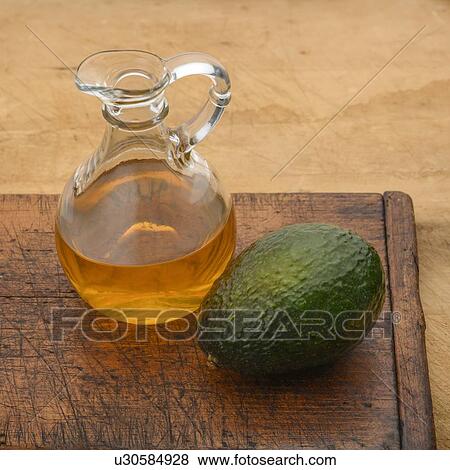 Avocado with pitcher of oil View Large Photo Image Stock Photo - Avocado with pitcher of oil. Fotosearch