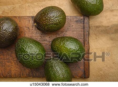 Avocados on cutting board View Large Photo Image Stock Photo - Avocados on cutting board. Fotosearch