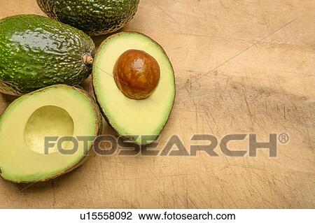 Stock Image - Avocados on wood. Fotosearch