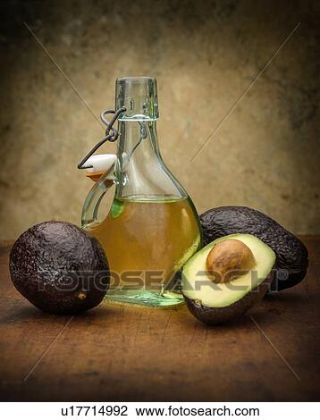 Avocados with bottle of oil View Large Photo Image Stock Image - Avocados with bottle of oil. Fotosearch