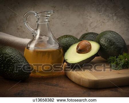 Stock Image - Avocados with pitcher of oil. Fotosearch