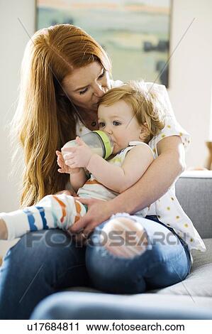 Baby boy drinking from bottle on his mother's lap View Large Photo Image Stock Image - Baby boy drinking from bottle on his mother's lap. Fotosearch