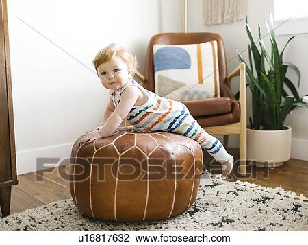 Baby boy lying on ottoman View Large Photo Image Stock Image - Baby boy lying on ottoman. Fotosearch