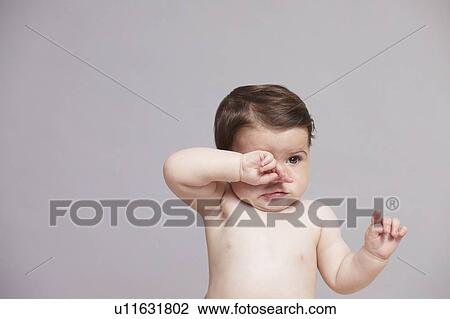Baby girl rubbing eyes View Large Photo Image Stock Image - Baby girl rubbing eyes. Fotosearch