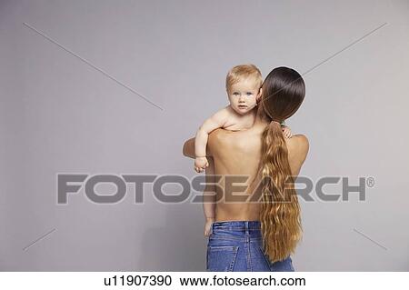 Stock Image - Baby looking over mother's shoulder. Fotosearch