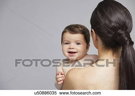 Stock Photography - Baby looking over mother's shoulder. Fotosearch