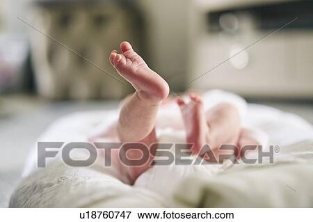 Stock Photo - Baby lying down on U-shaped pillow at home. Fotosearch