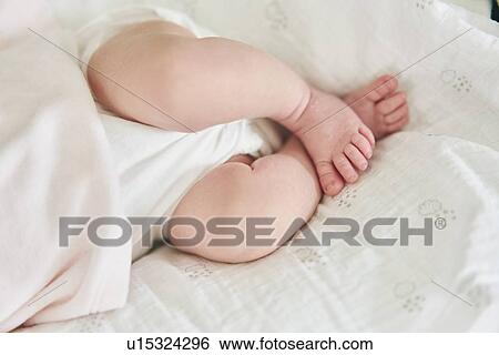 Baby lying down on U-shaped pillow View Large Photo Image Stock Photograph - Baby lying down on U-shaped pillow. Fotosearch