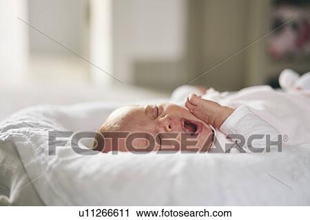 Stock Image - Baby sleeping on U-shaped pillow at home. Fotosearch