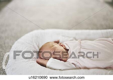 Stock Image - Baby sleeping on U-shaped pillow at home. Fotosearch