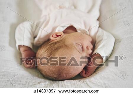 Stock Photo - Baby sleeping on U-shaped pillow at home. Fotosearch