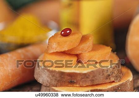 Stock Photo - Beta carotene supplement pills and vegetables. Fotosearch