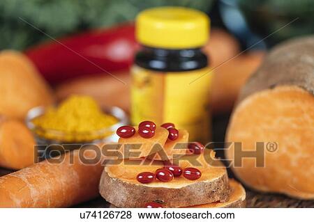 Stock Photo - Beta carotene supplement pills and vegetables. Fotosearch