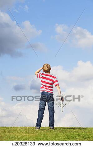 Boy playing with toy plane View Large Photo Image Stock Photo - Boy playing with toy plane. Fotosearch