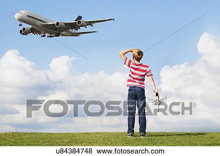 Boy playing with toy plane View Large Photo Image Stock Photo - Boy playing with toy plane. Fotosearch