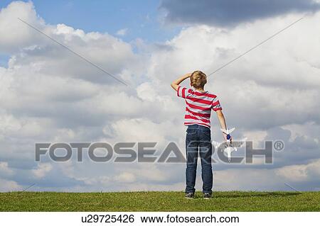 Boy playing with toy plane View Large Photo Image Stock Photograph - Boy playing with toy plane. Fotosearch