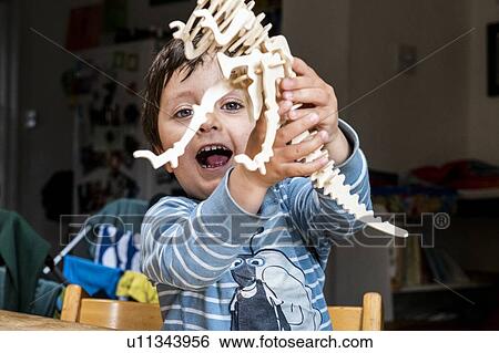 Boy playing with wooden dinosaur View Large Photo Image Stock Photograph - Boy playing with wooden dinosaur. Fotosearch