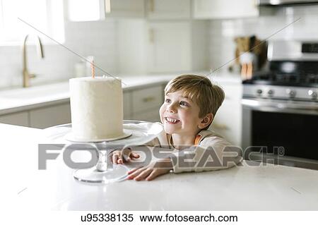 Boy smiling at birthday cake View Large Photo Image Stock Photography - Boy smiling at birthday cake. Fotosearch