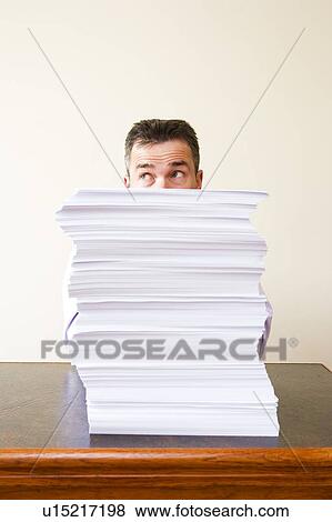 Businessman behind stack of papers View Large Photo Image Stock Photo - Businessman behind stack of papers. Fotosearch