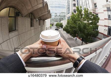 Stock Photo - Businessman holding disposable coffee cup. Fotosearch