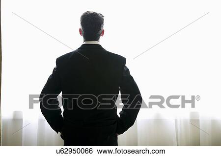 Stock Photograph - Businessman looking out of window. Fotosearch