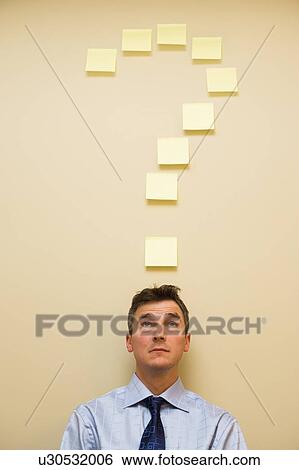Stock Photograph - Businessman standing underneath question mark. Fotosearch